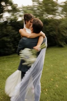 two people hugging each other in the grass