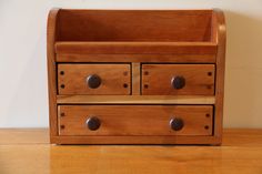 a wooden drawer with three drawers on it