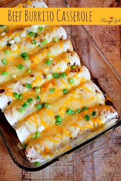 a casserole dish with chicken, cheese and green onions in it on a wooden table