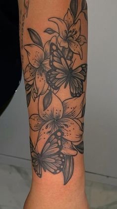 a woman's leg with flowers and butterflies tattoo on the side of her body