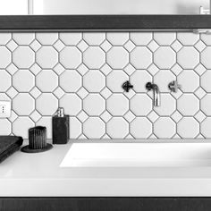 black and white photograph of bathroom sink with soap dispenser on countertop