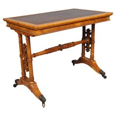 an old wooden table with wheels on the legs and a leather top, sitting against a white background