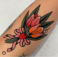 a flower tattoo on the arm with leaves and flowers in red, yellow and pink colors