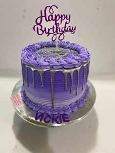 a birthday cake with purple frosting and icing