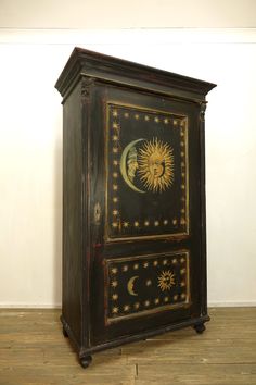 an old wooden cabinet with sun and moon painted on it