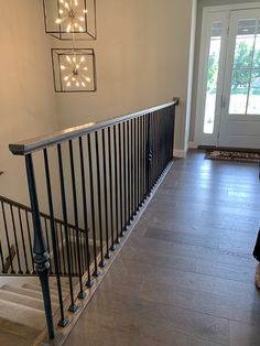 a woman is walking up the stairs in front of a door with lights on it