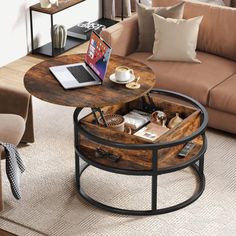 a coffee table with a laptop on it in the middle of a living room filled with furniture