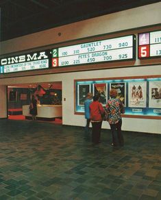 two people standing in front of a movie theater