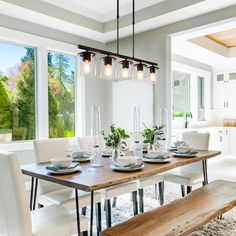 a dining room table with white chairs and wooden bench in front of large windows that look out onto the outdoors