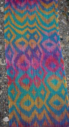 a multicolored scarf laying on the ground