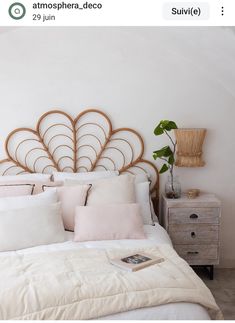 a bed with white linens and pillows on it, next to a wooden dresser