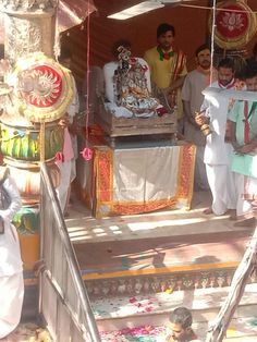 several men standing in front of a shrine with an idol on the steps to it