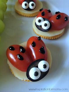 three little ladybug cupcakes on a plate with grapes in the background