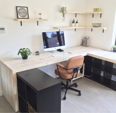 a desk with a chair and computer on it in a room that has white walls