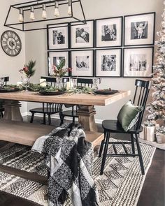 a dining room table with chairs and pictures on the wall above it, surrounded by christmas decorations