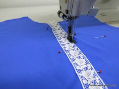 the sewing machine is working on the blue fabric