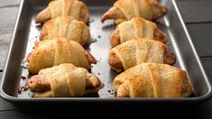 several pastries are lined up on a baking sheet, ready to be baked in the oven