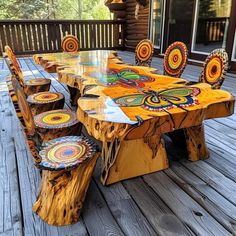 an outdoor table and chairs made out of tree stumps with colorful designs on them