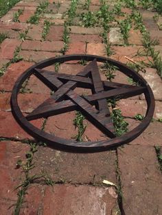 a wooden pentagram sitting on top of a brick walkway