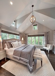 a large bed sitting in the middle of a bedroom on top of a hard wood floor