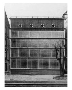 an old black and white photo of a building with several windows on the side of it