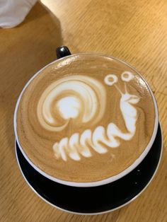 a cappuccino with an animal drawn on it's latte art