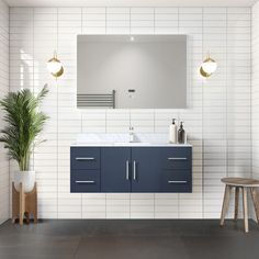 a bathroom with white tiles and blue cabinetry on the wall, along with a plant