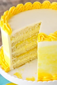 a white cake with yellow frosting and one slice cut out from the rest of it