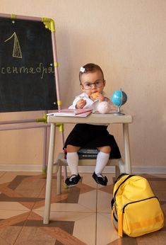 a small child sitting at a table with a book