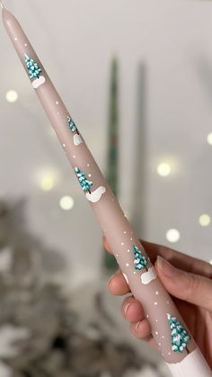 a hand holding a pink and white toothbrush decorated with blue snowflakes