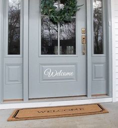 a welcome mat on the front door of a house with a wreath hanging from it