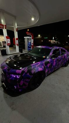 a purple camouflage camo car parked at a gas station