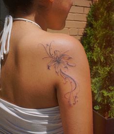 a woman with a flower tattoo on her back shoulder