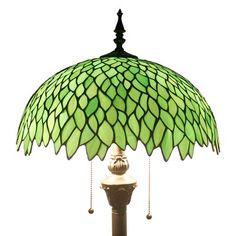 a lamp that is sitting on top of a table with a green shade over it