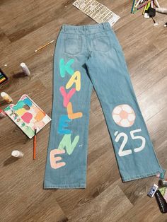 a pair of jeans that have been decorated with letters and numbers are on the floor