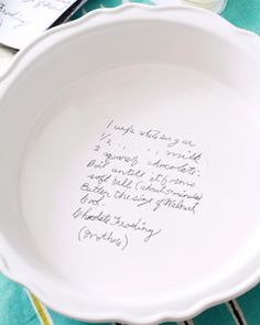 a white bowl with writing on it sitting on top of a blue and green table cloth