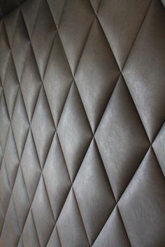 a close up view of a wall made out of brown leathers with diamond patterning