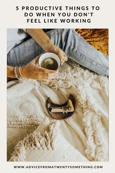 a woman sitting on the floor holding a cup of tea