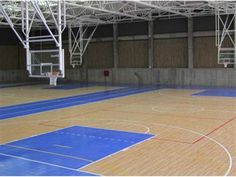 an indoor basketball court with blue and red markings