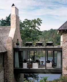 the house is surrounded by water and stone walls, along with an outdoor dining area