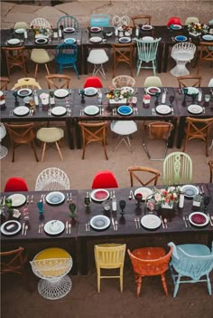 tables and chairs are set up for an outdoor dinner party with colorful plates and place settings