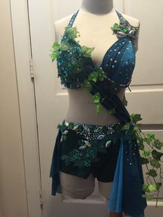 a mannequin with green and blue decorations on it's torso, standing in front of a door