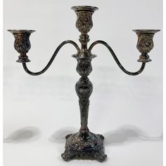 an ornate metal candelabra with three candles on each arm and one candle holder in the middle