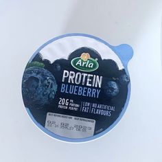 blueberry yogurt in a bowl on a white surface with an ad for arla protein