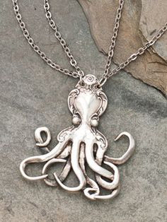 an octopus necklace is sitting on a rock