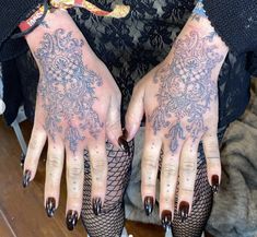 a woman's hands with tattoos and fishnet stockings