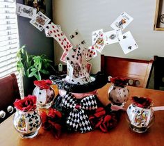 a wooden table topped with vases filled with cards