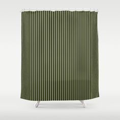 a shower curtain with green and white stripes on the outside, in front of a gray background