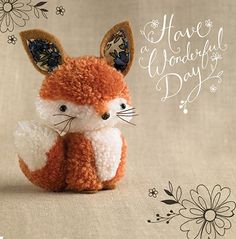 a small stuffed fox sitting on top of a table next to a flowered background