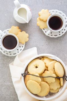 two cups of coffee and some cookies on a table